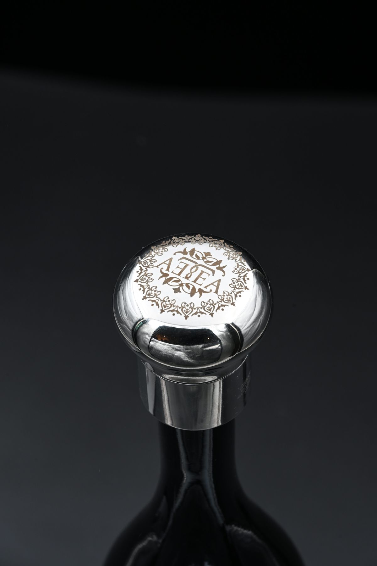 Metal bottle stopper engraved with a brand logo